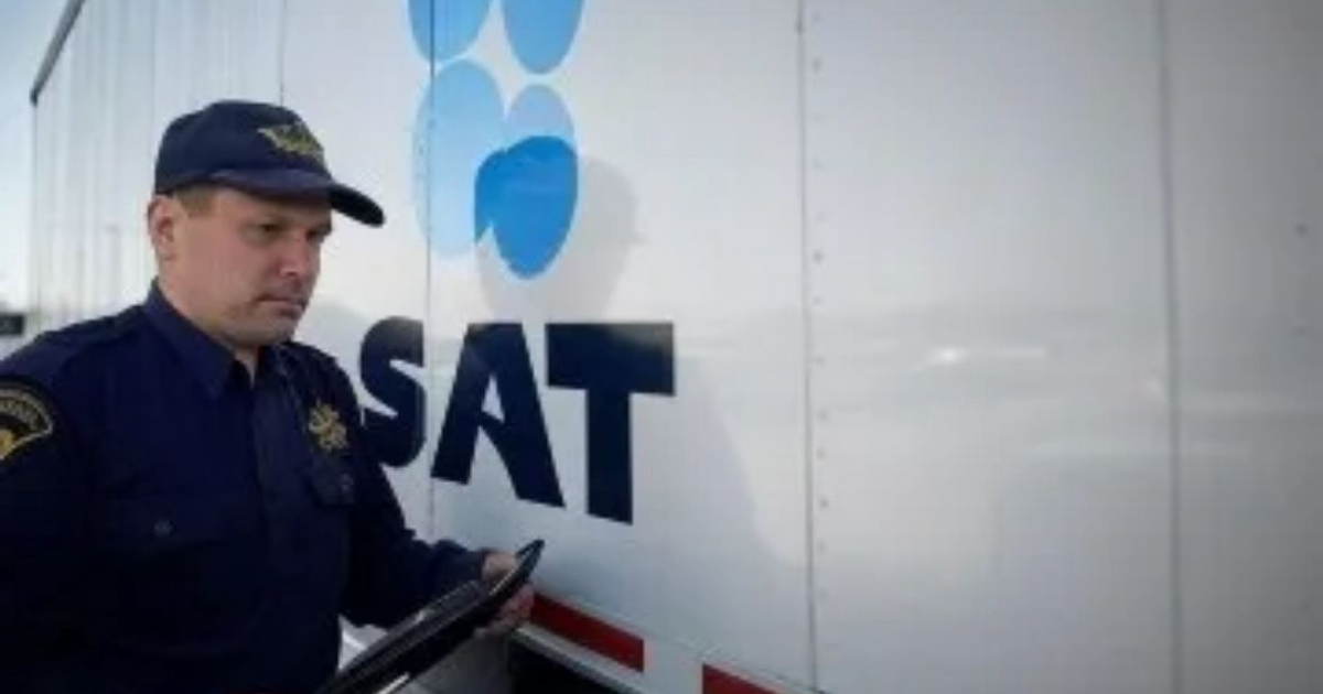 Oficial del SAT con tableta junto a vehículo con logo del SAT