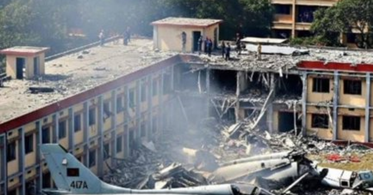 Escena de destrucción tras accidente aéreo en Dhaka, con edificio dañado y humo.