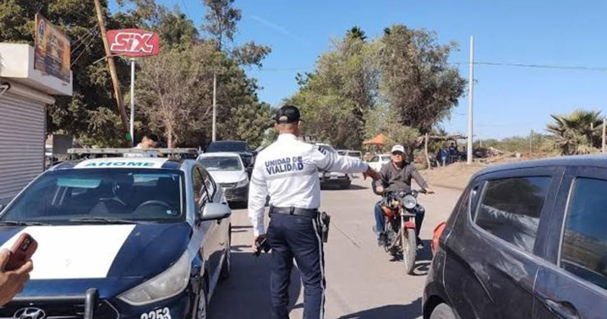 Oficial de tráfico dirigiendo vehículos en carretera urbana con presencia de policía y motociclista.