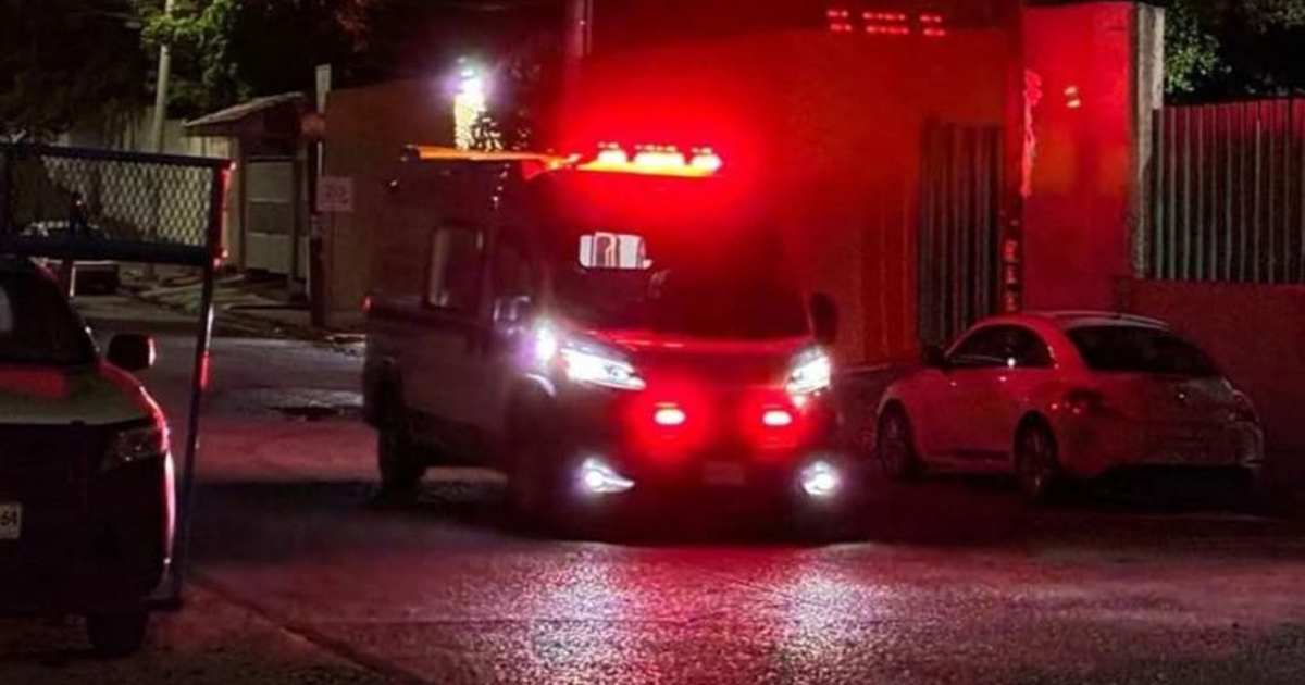 Ambulancia con luces de emergencia en calle oscura tras tiroteo en Culiacán