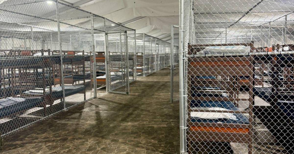 Vista de literas vacías en el centro de detención 'Alcatraz de los Caimanes', con cercas de alambre y suelo de mosaico.