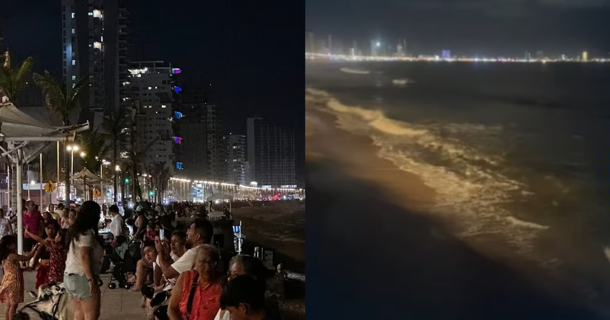Multitud en el malecón de Mazatlán durante alerta de tsunami, con paseo marítimo iluminado y playa nocturna.