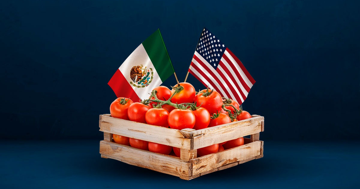 Caja de madera con tomates frescos y banderas de México y EE.UU., simbolizando el arancel al jitomate mexicano.