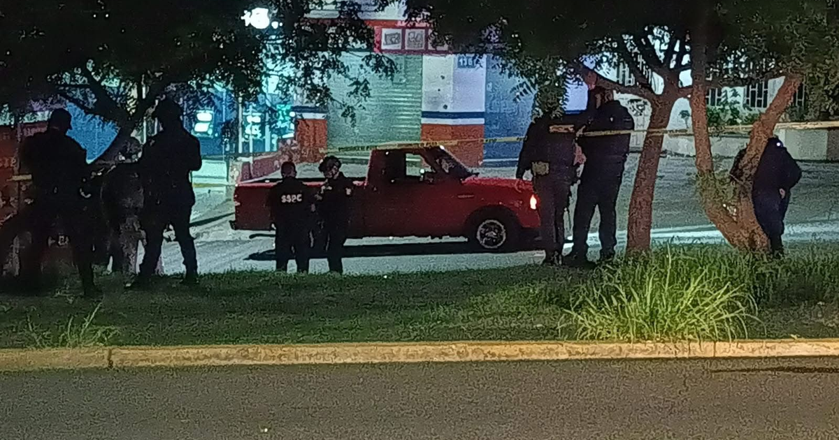 Policías en escena nocturna alrededor de camioneta roja en Culiacán, con cinta de advertencia visible.