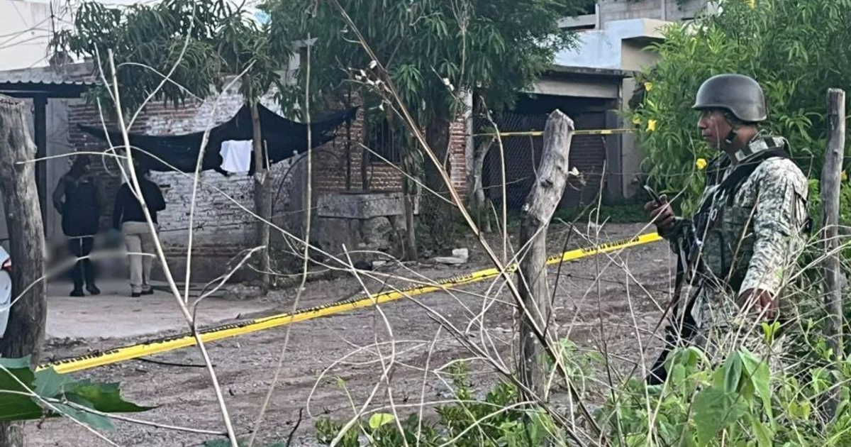Soldado en operativo de seguridad en Culiacán, con cinta amarilla de zona restringida y personas al fondo.