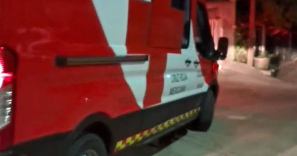 Ambulancia roja y blanca estacionada en una calle urbana de noche, relacionada con un ataque armado en Culiacán.