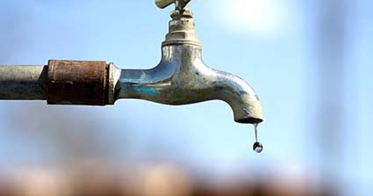 Grifo de metal goteando con fondo de cielo claro, simbolizando la crisis de agua en Los Mochis.