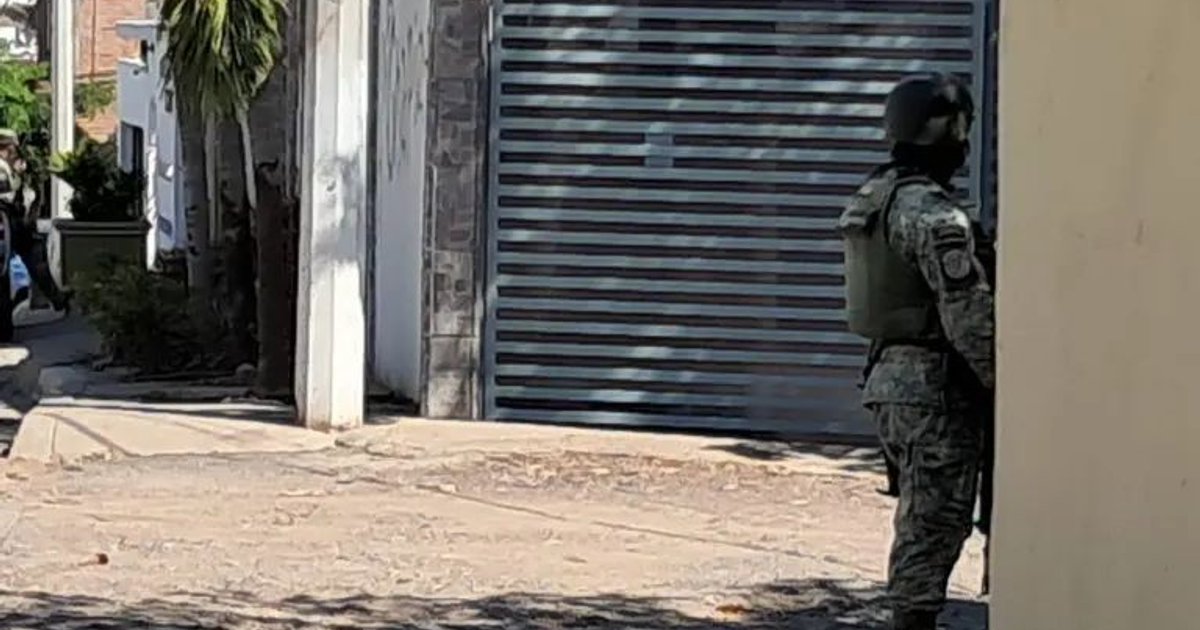 Militar en uniforme camuflado vigilando un callejón urbano en Culiacán.