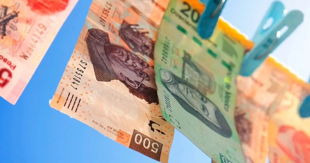 Billetes de 500 y 20 colgados con pinzas de ropa sobre un cielo azul, representando sanciones financieras.