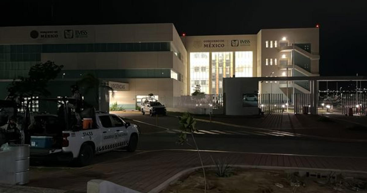 Edificio gubernamental iluminado de noche con vehículos de seguridad en México