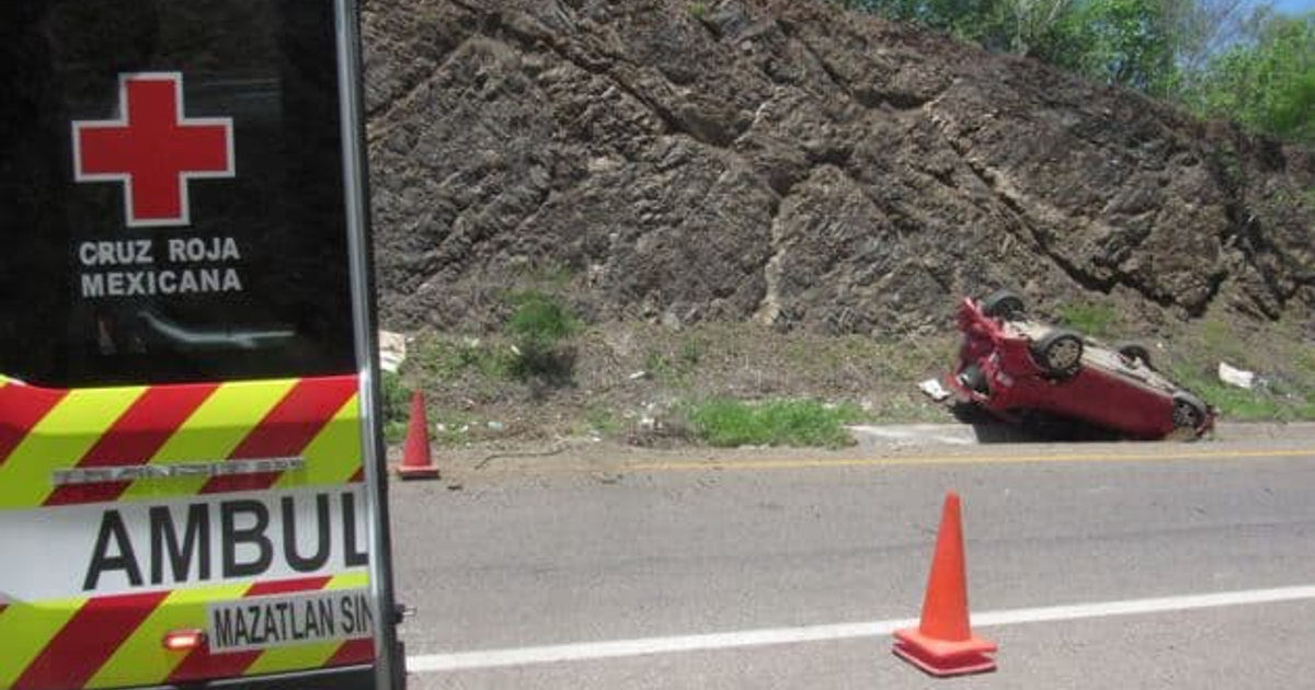 Ambulancia de la Cruz Roja Mexicana junto a un coche rojo volcado en la carretera Tepic–Mazatlán.