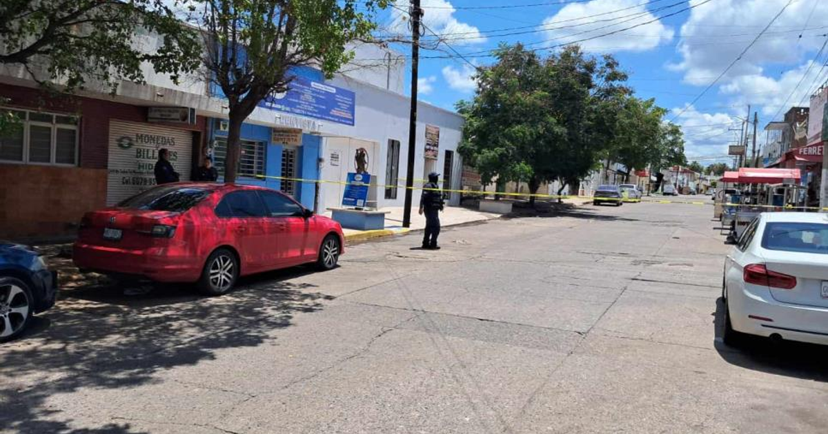 Calle acordonada en Culiacán tras balacera, con policía y vehículos estacionados.