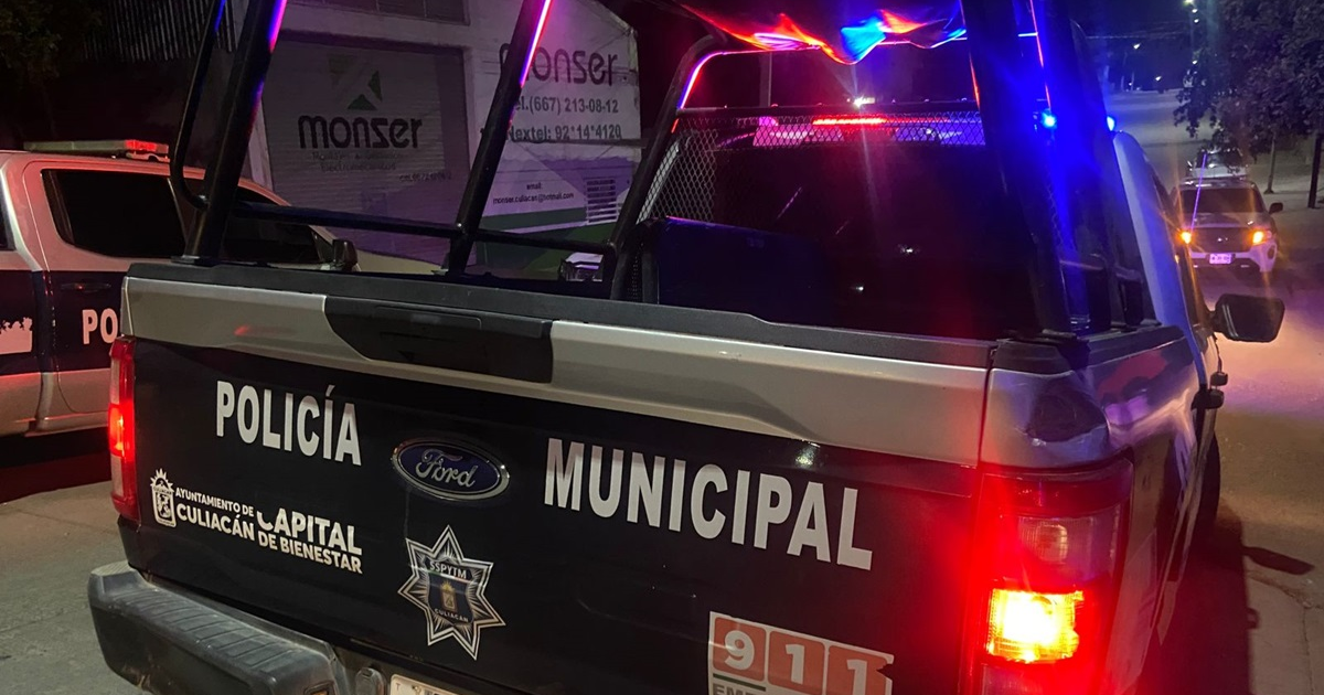 Camioneta de policía municipal de Culiacán con luces intermitentes encendidas durante la noche.