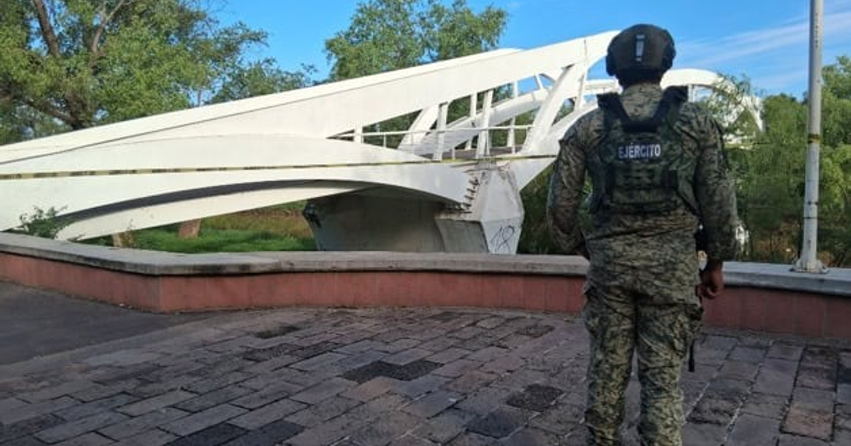 Soldado de espaldas en uniforme militar frente a un puente moderno en Culiacán