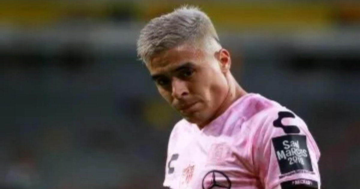 Jugador de fútbol con uniforme rosa en acción durante un partido