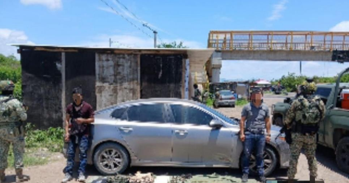 Operativo de seguridad en Tecualillas con detención de civiles armados junto a un automóvil plateado.