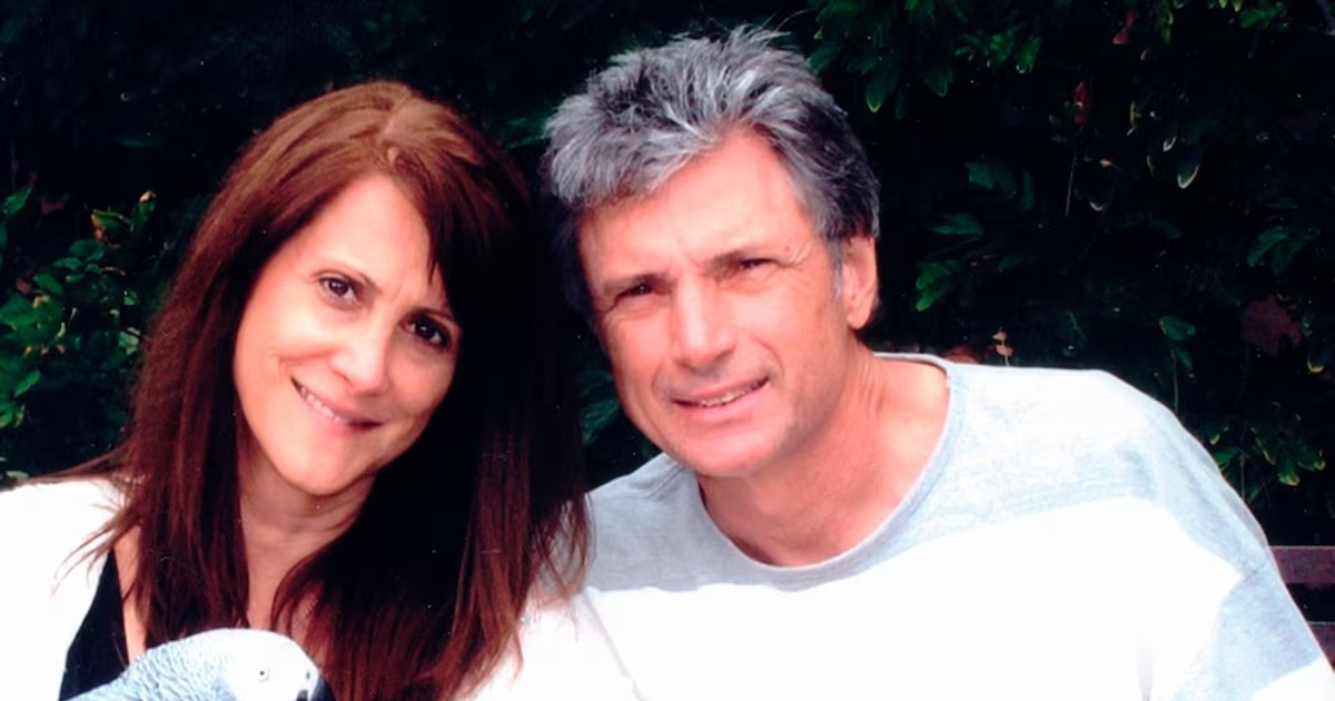 Mujer y hombre sonrientes con un loro en un entorno natural