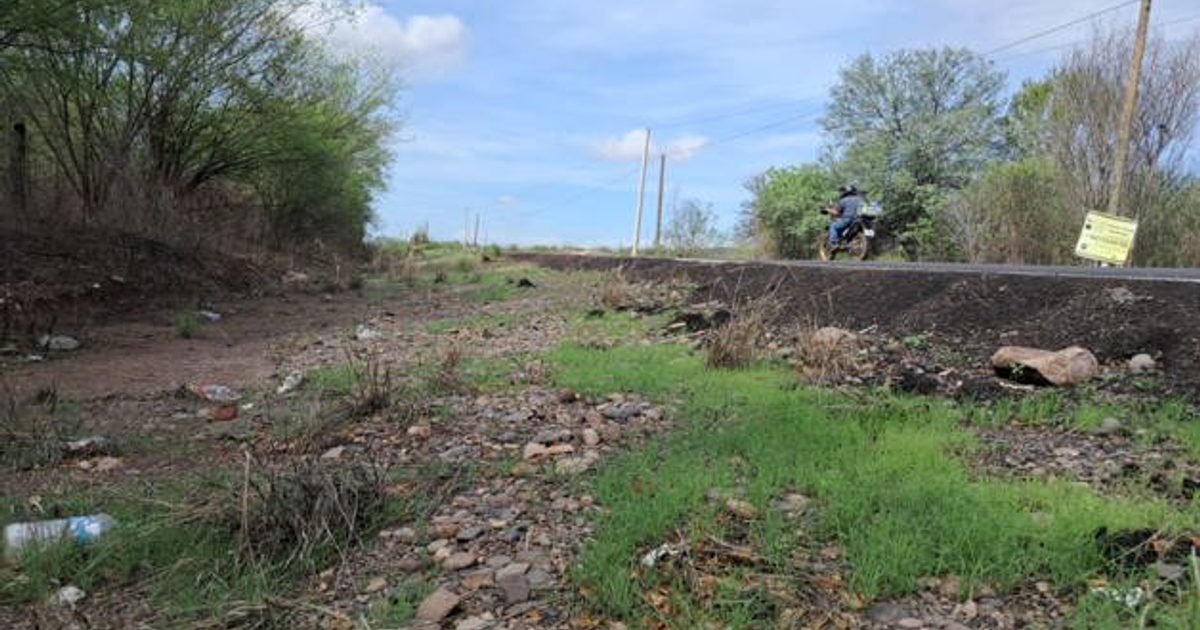 Paisaje desolado en Culiacán con carretera y motociclista, relacionado con un homicidio en 'la Y'.