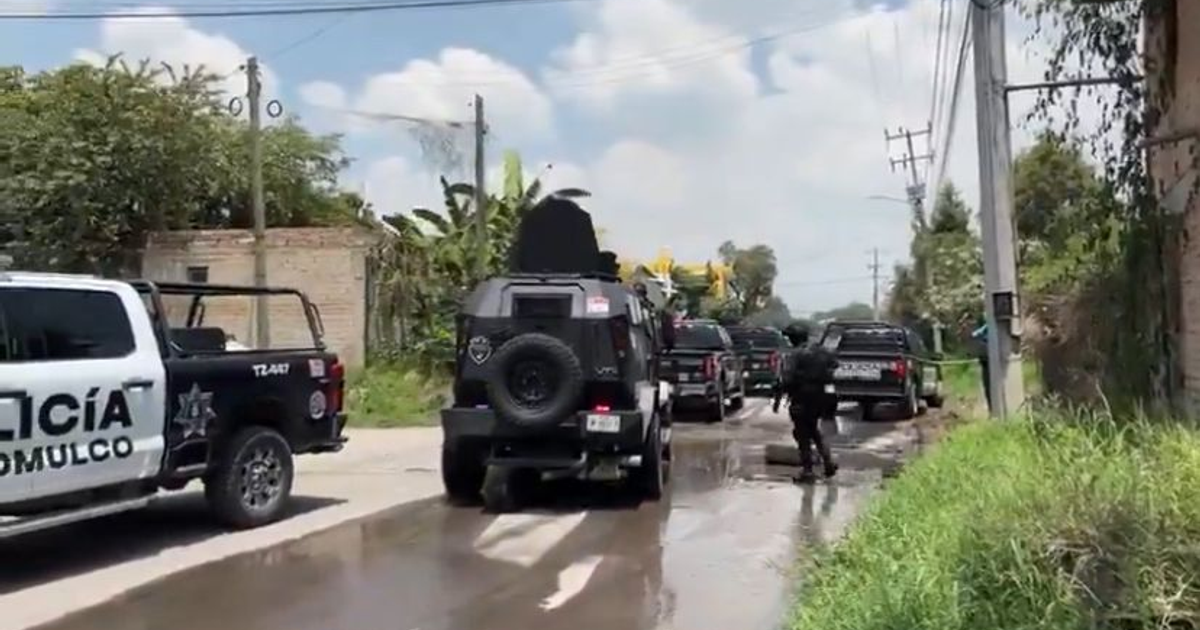 Operativo policial en San Sebastián El Grande con vehículos y oficial de policía en un entorno urbano mojado.