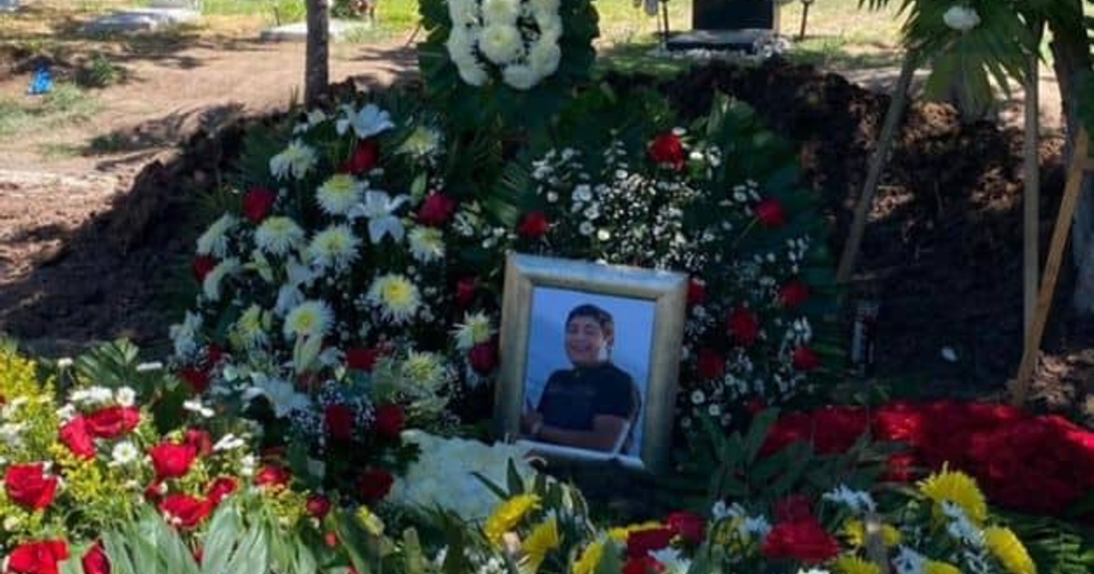 Altar con flores rojas y blancas en memoria de un joven de la familia Vázquez en un cementerio.