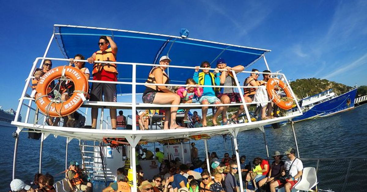 Grupo de personas en un barco en Mazatlán, disfrutando del paseo bajo un cielo soleado.
