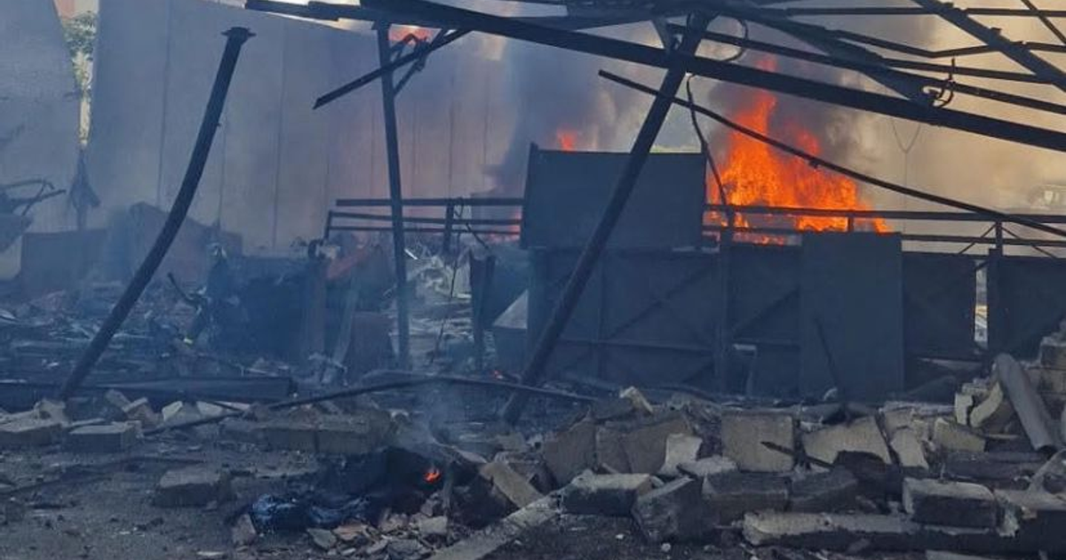 Escena de destrucción tras explosión en gasolinera de Roma, con fuego, humo y escombros visibles.