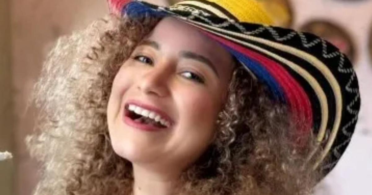 Mujer sonriente con cabello rizado y sombrero colorido, vinculada a la noticia de urgencia hospitalaria de Mayra Tercero.