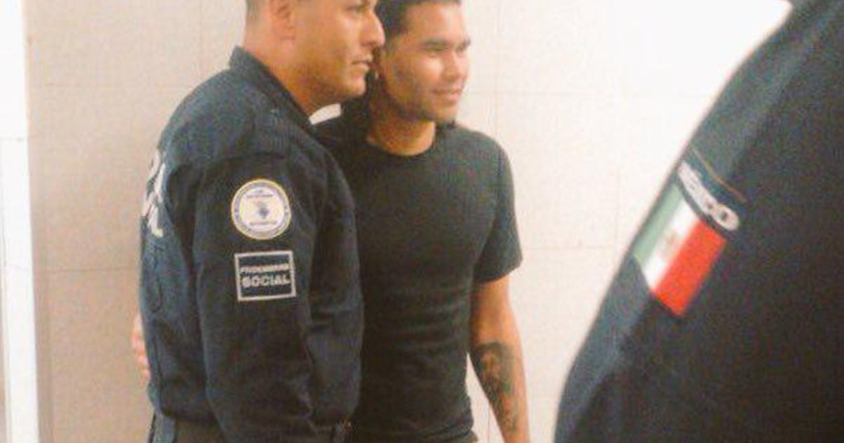 Oficiales de policía posan con Carlos 'Gullit' Peña tras su detención por manejo bajo influencia.