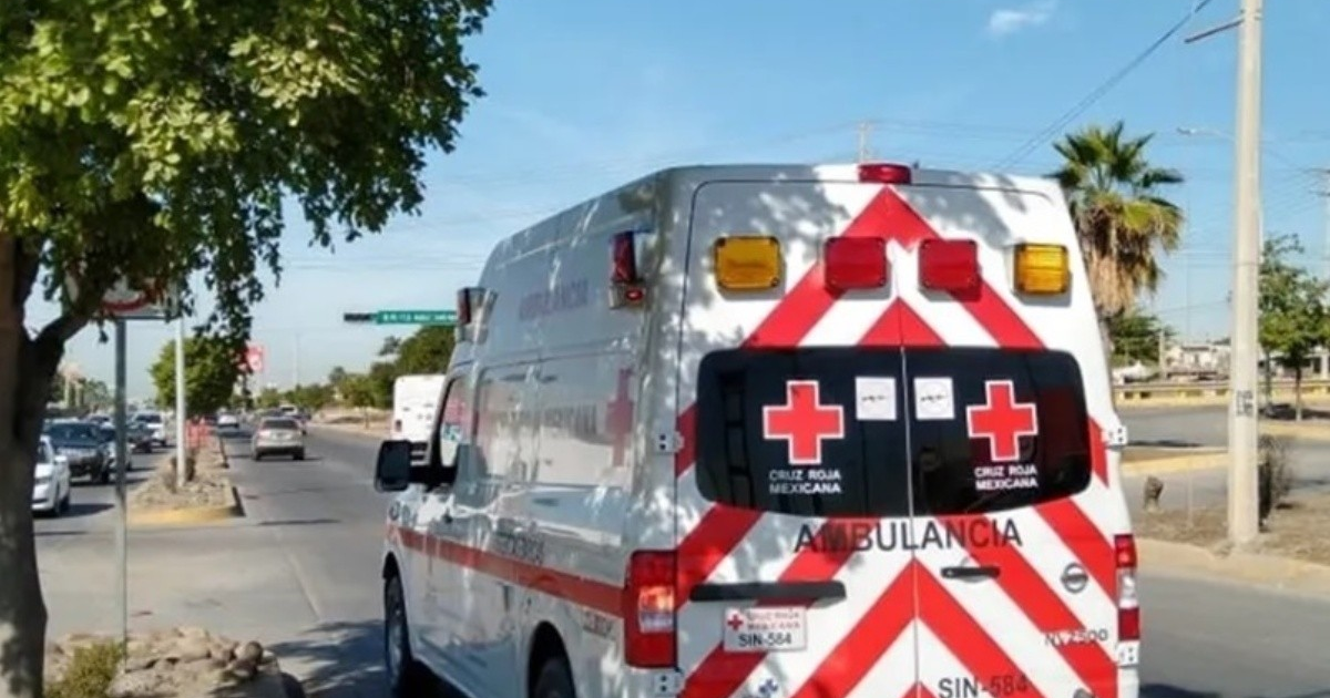 Ambulancia de la Cruz Roja Mexicana estacionada en una calle de Culiacán, con árboles y vehículos alrededor.