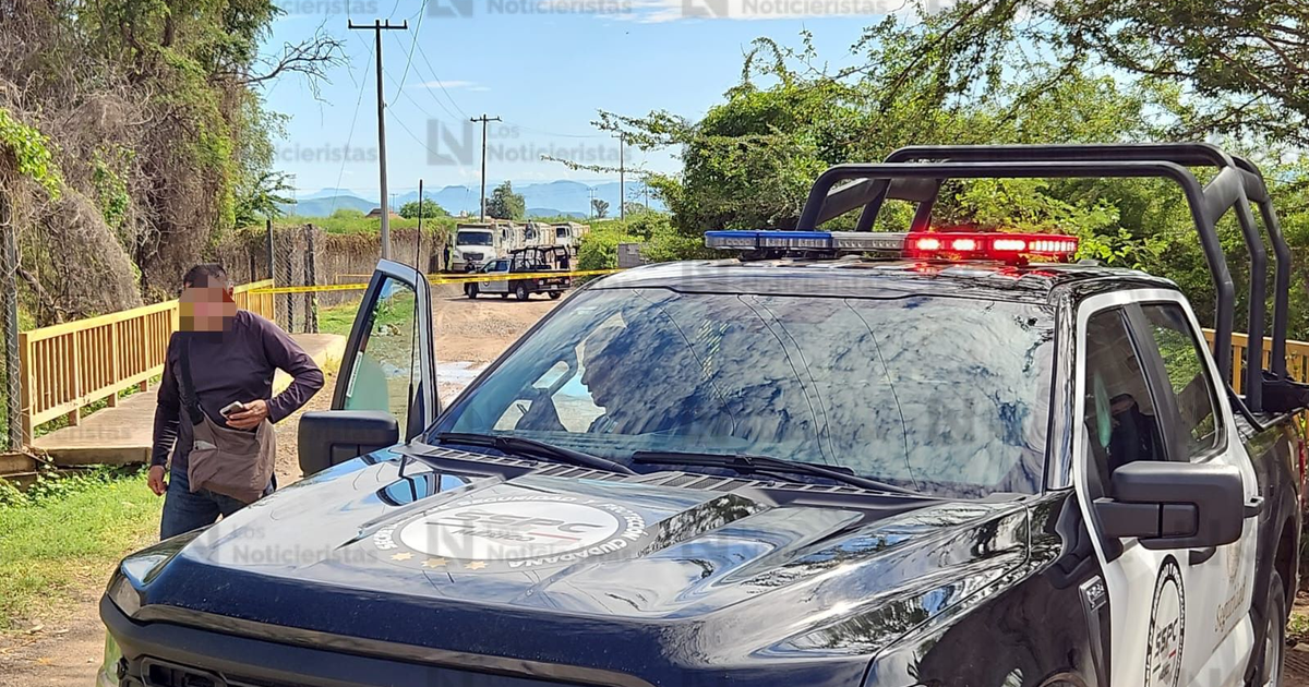 Camioneta de policía en zona rural de Culiacán, relacionada con un caso de homicidio.