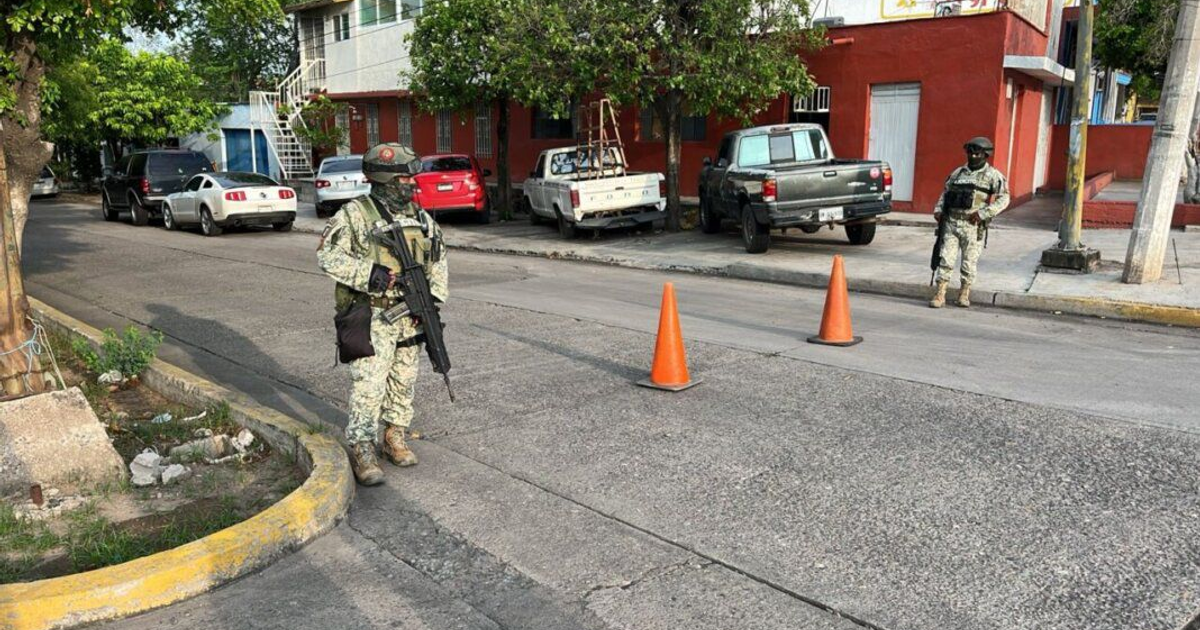 Dos militares en vigilancia urbana con equipo y armamento en Culiacán, cerca de una zona de hallazgo de cadáver.