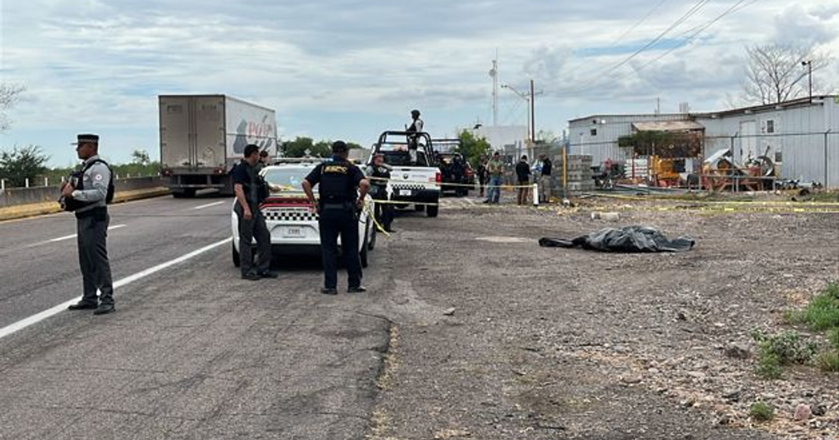 Autoridades investigan escena del crimen en autopista Benito Juárez, con presencia de policía y área acordonada.
