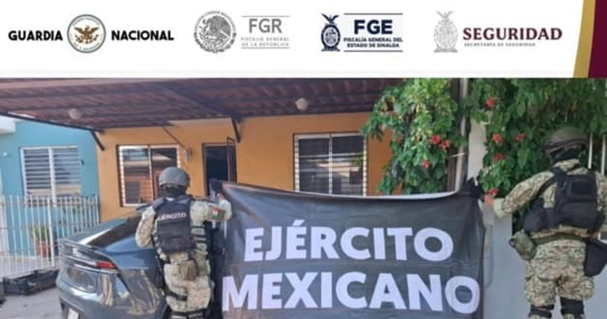 Dos soldados del Ejército Mexicano con un cartel en un operativo de seguridad en Culiacán.