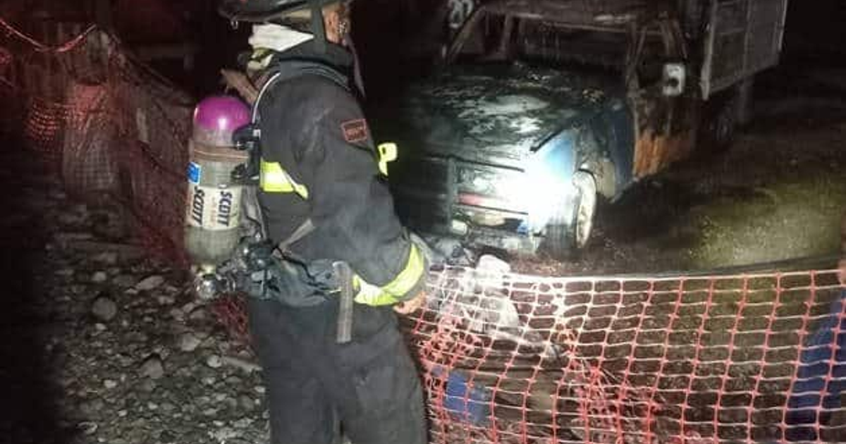 Bombero con equipo de protección frente a camioneta incendiada en Mazatlán