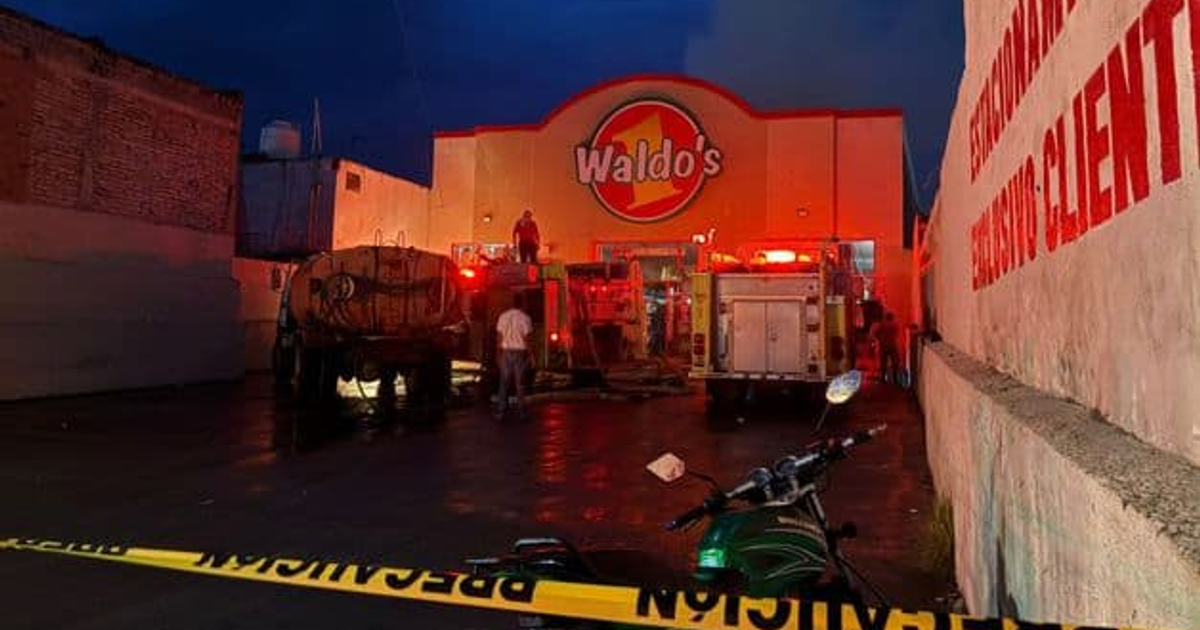 Vehículos de bomberos con luces encendidas en Waldo's durante un incendio nocturno en Escuinapa.