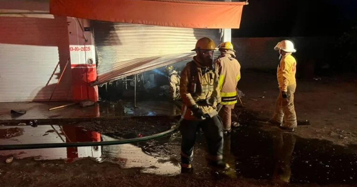 Bomberos combatiendo incendio nocturno en tortillería de Camajoa
