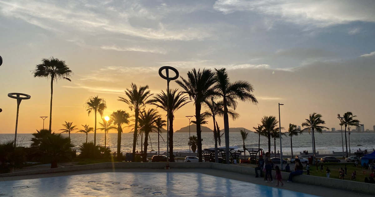 Atardecer en la costa de Mazatlán con palmeras y el sol en el horizonte