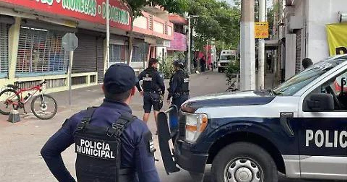 Policías en operación en Montelargo, Sinaloa, con vehículo policial y comercio cercano.