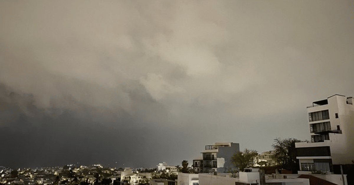 Paisaje urbano nocturno en Culiacán con cielo nublado y luces de la ciudad