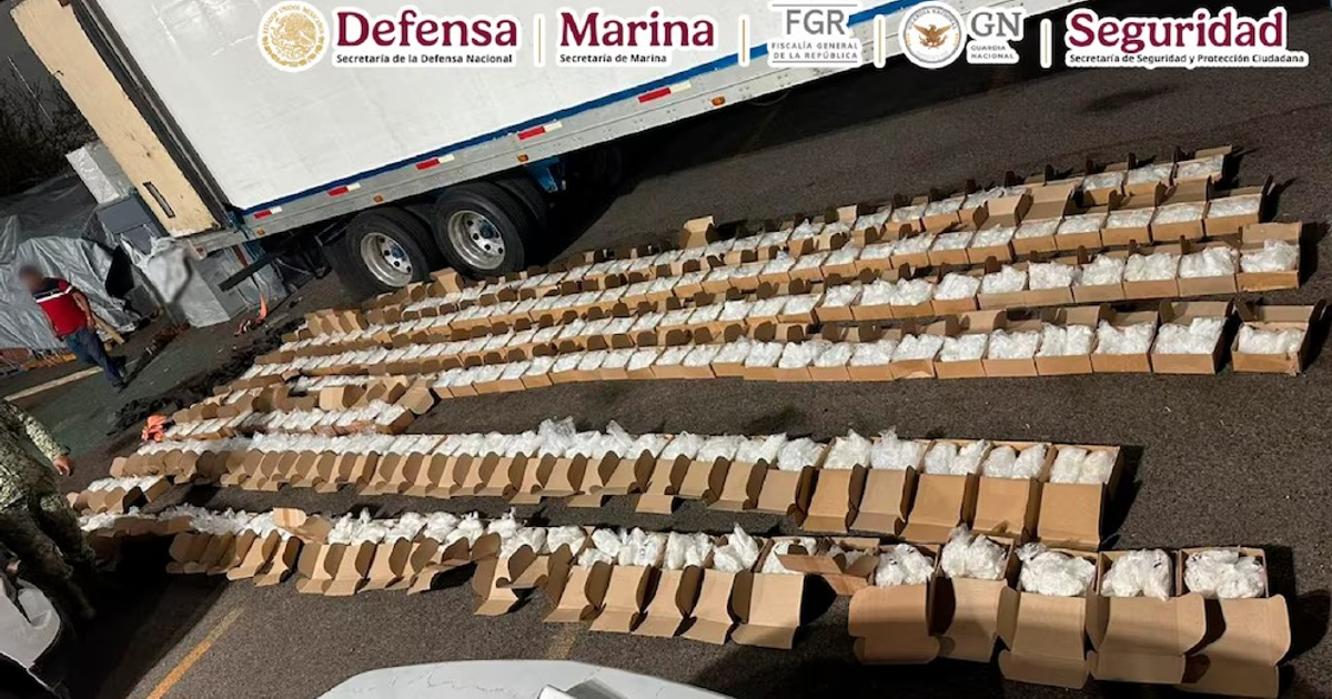 Cajas de metanfetamina decomisadas en operativo en La Paz, supervisadas por personal de seguridad.