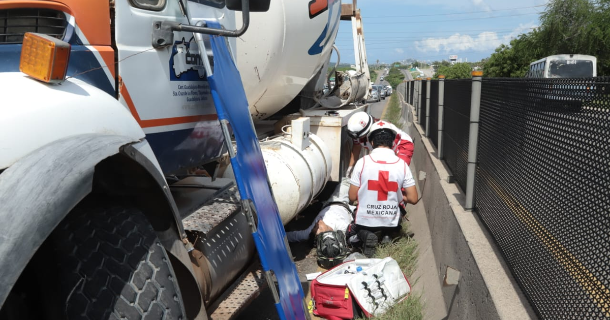 Paramédicos de la Cruz Roja Mexicana atienden a un motociclista herido en la carretera de Mazatlán tras un accidente con un tráiler y un camión revolvedor de cemento.