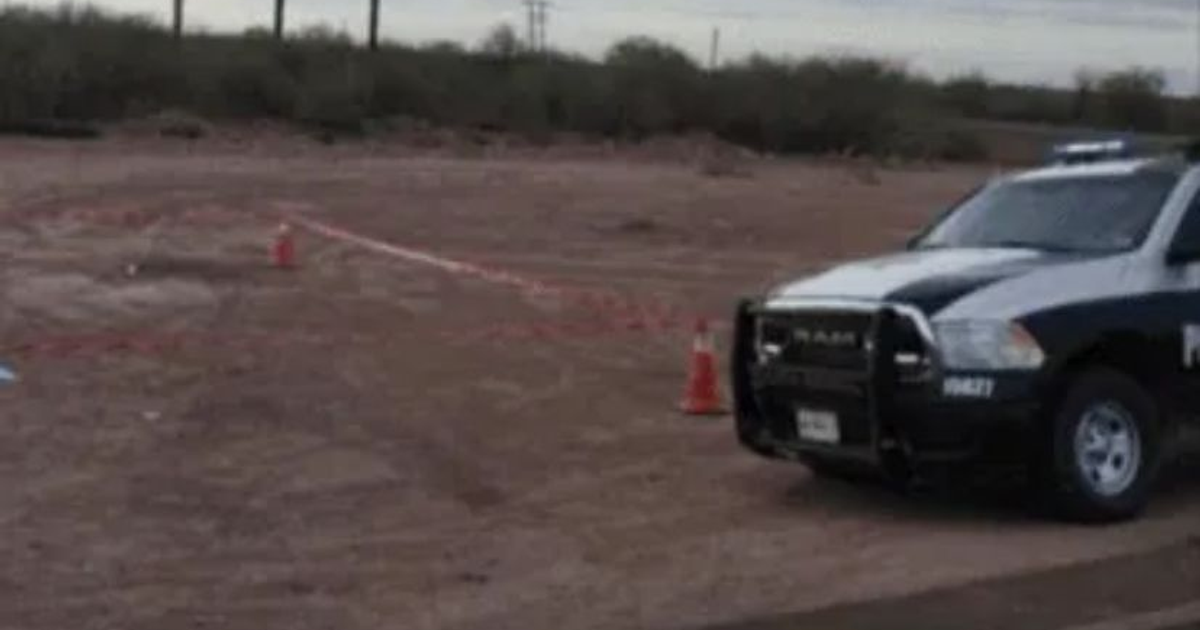 Vehículo policial en área desértica con conos de tráfico y cinta de seguridad, relacionado con investigación de crimen en Hermosillo.