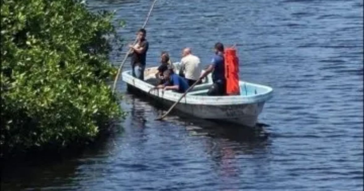 Grupo de personas en bote navegando por manglares durante búsqueda de niño desaparecido en el estero de Santa Ana.