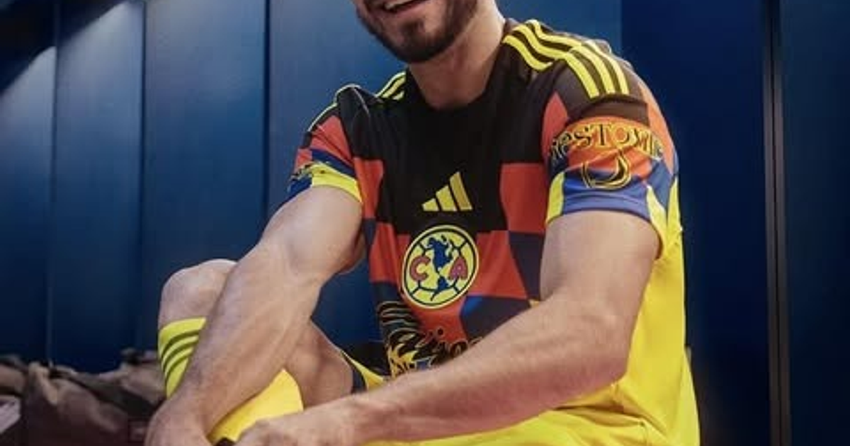 Persona sonriendo mientras se viste con la nueva camiseta del Club América 2025 en un vestidor deportivo.