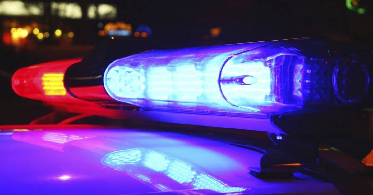 Sirena de vehículo policial con luces azul y rojo en la escena del crimen nocturna en Culiacán.