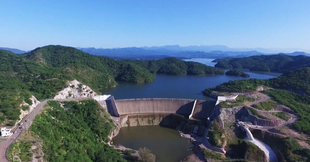 Vista aérea de la presa Huites en Sinaloa rodeada de montañas y un lago.