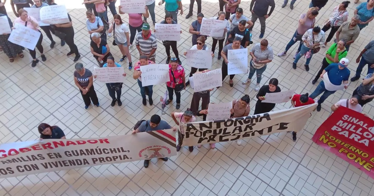 Grupo de manifestantes con carteles en protesta pacífica frente al Palacio de Gobierno.