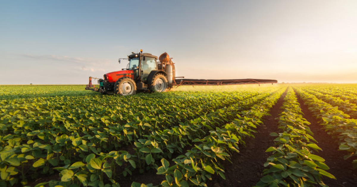 Tractor rojo en campo agrícola de Texas, afectado por redadas del ICE