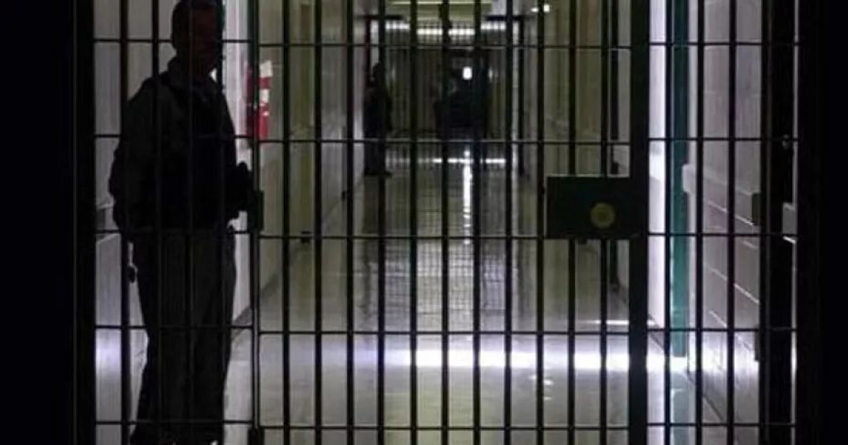 Pasillo de prisión con barrotes y persona de pie, simbolizando la sentencia por hurto de vehículo en Culiacán.