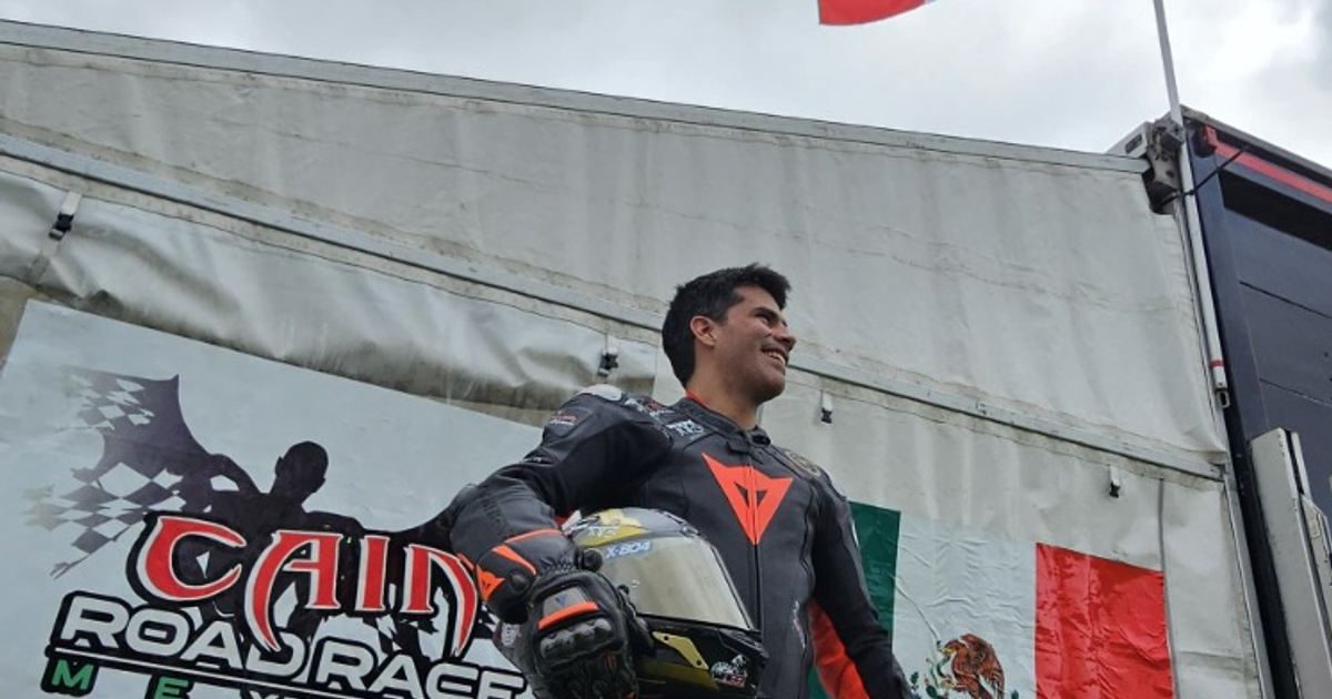 Gonzalo Castro, piloto mexicano, sonríe sosteniendo un casco con la bandera mexicana de fondo en el Southern 100.